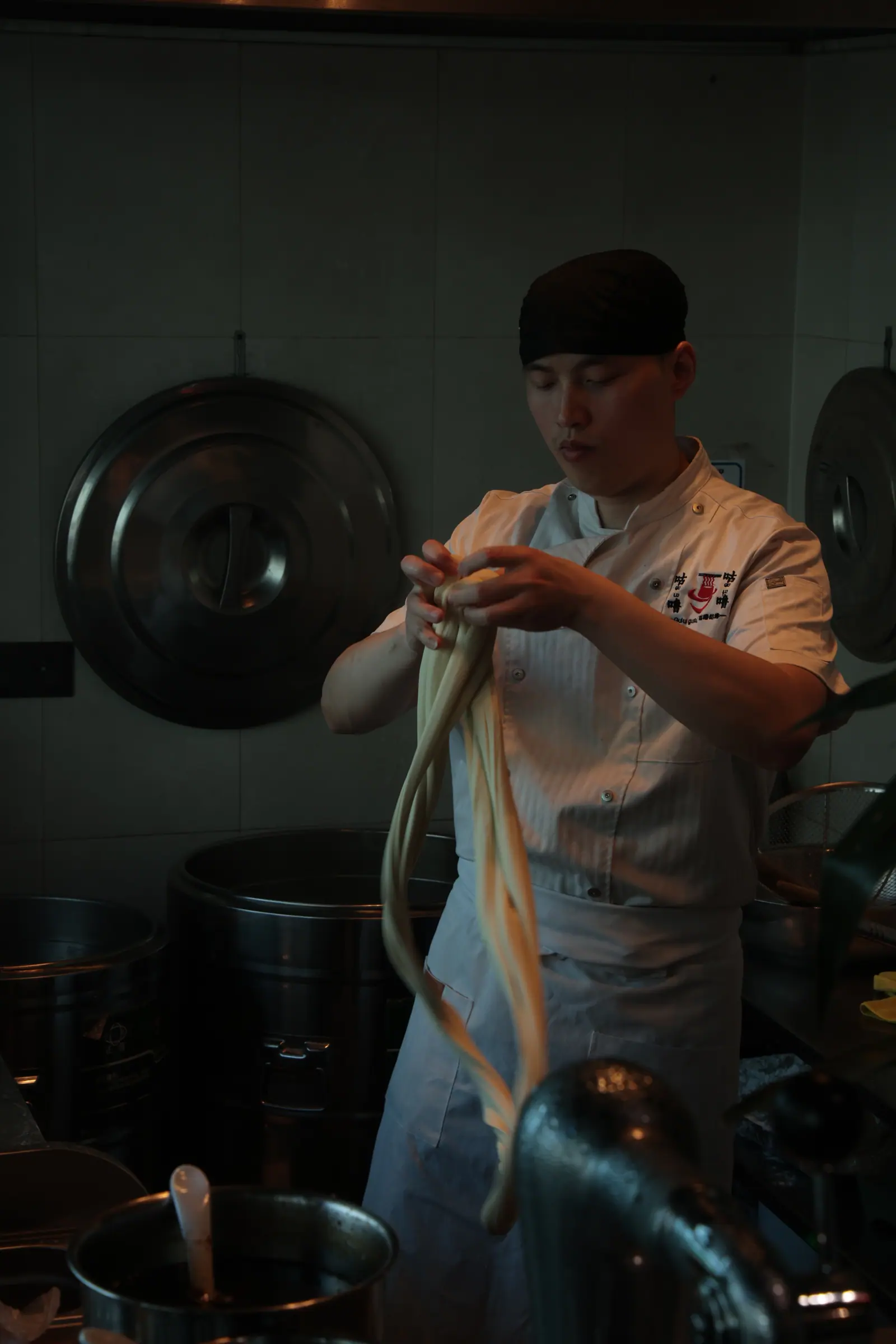Kucharz Gulu Gulu ciągnie makaron lamian